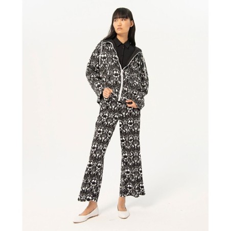 Chubasquero reversible con lado estampado y liso negro.