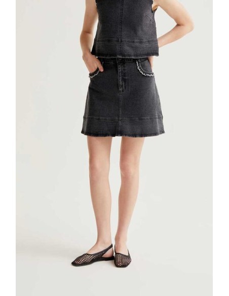 FALDA CORTA DENIM NEGRA CON DETALLE DE VOLANTES.
